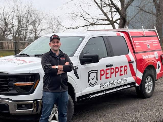 Richard Pepper beside a Pepper Pest Prevention service vehicle